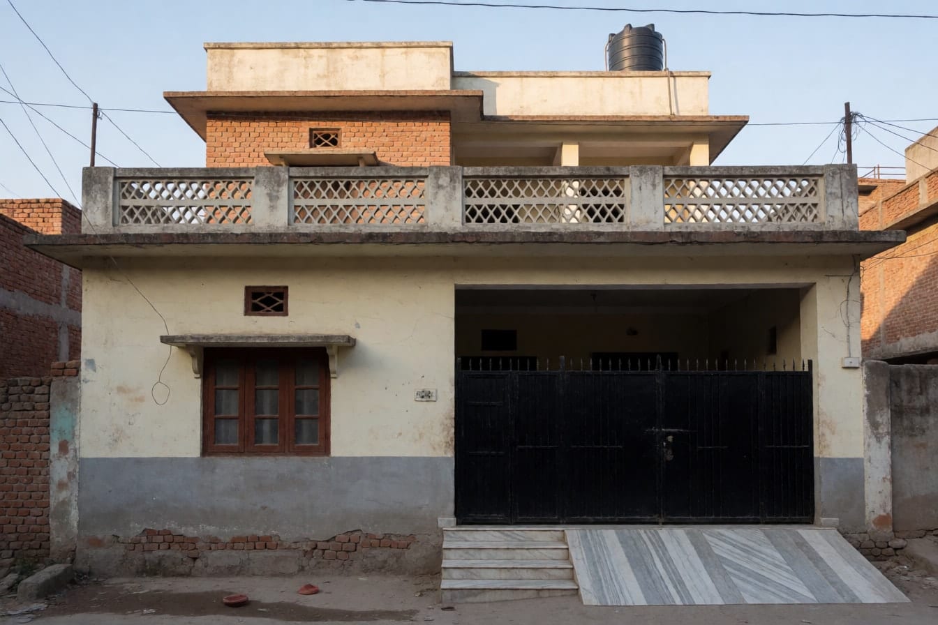 उत्तर भारत के कस्बे की दो मंज़िला कोठी, धूसर पड़ी क्रीम दीवारें, सीमेंट जाली वाली बालकनी, काला लोहे का गेट और छत पर पानी की टंकी