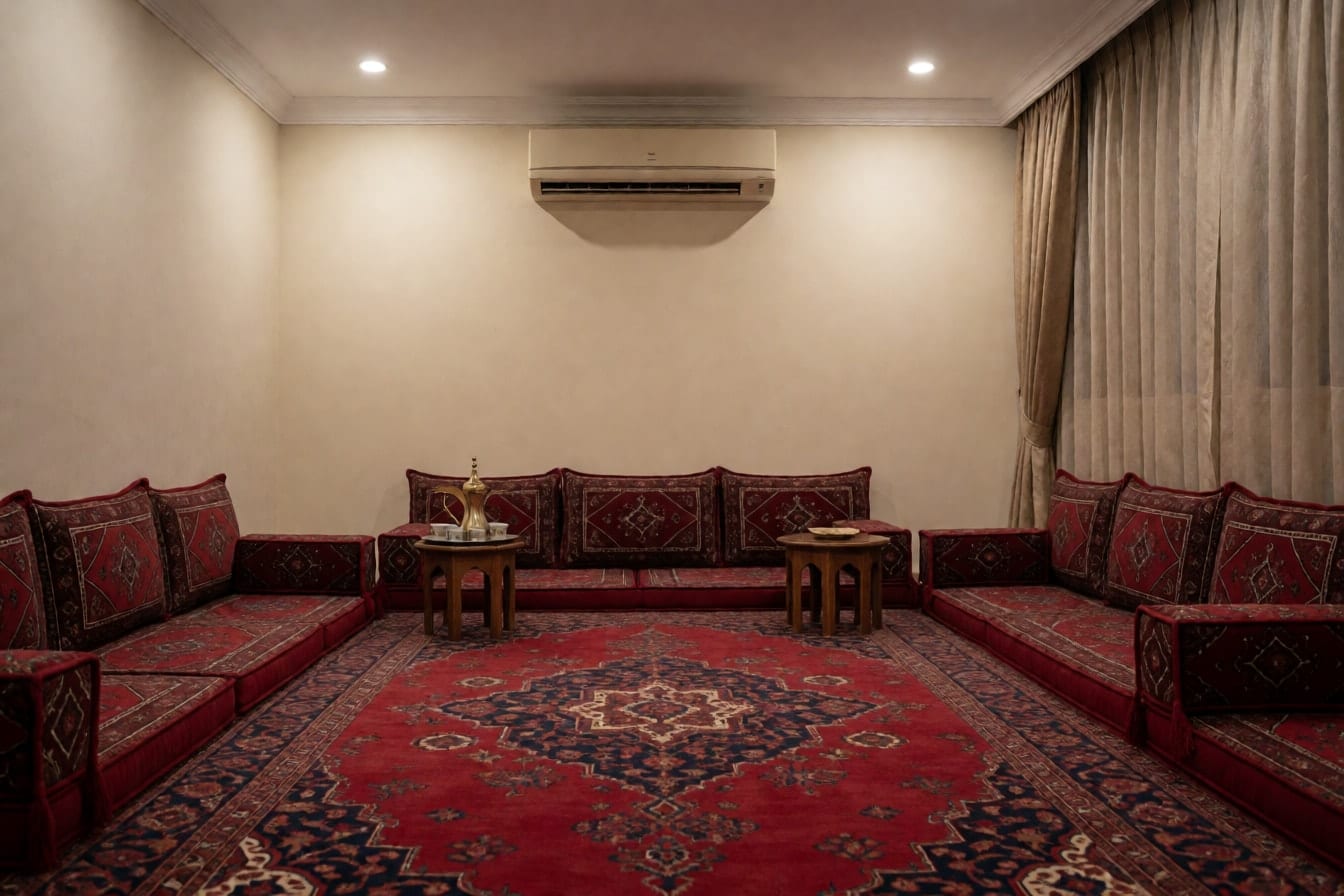 مجلس تقليدي بجلسات أرضية حمراء على امتداد الجدران وسجادة كبيرة ودلة قهوة على صينية